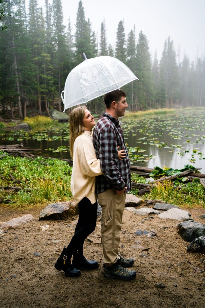 wife hugging her husband from behind during their rocky mountain national park engagement session
