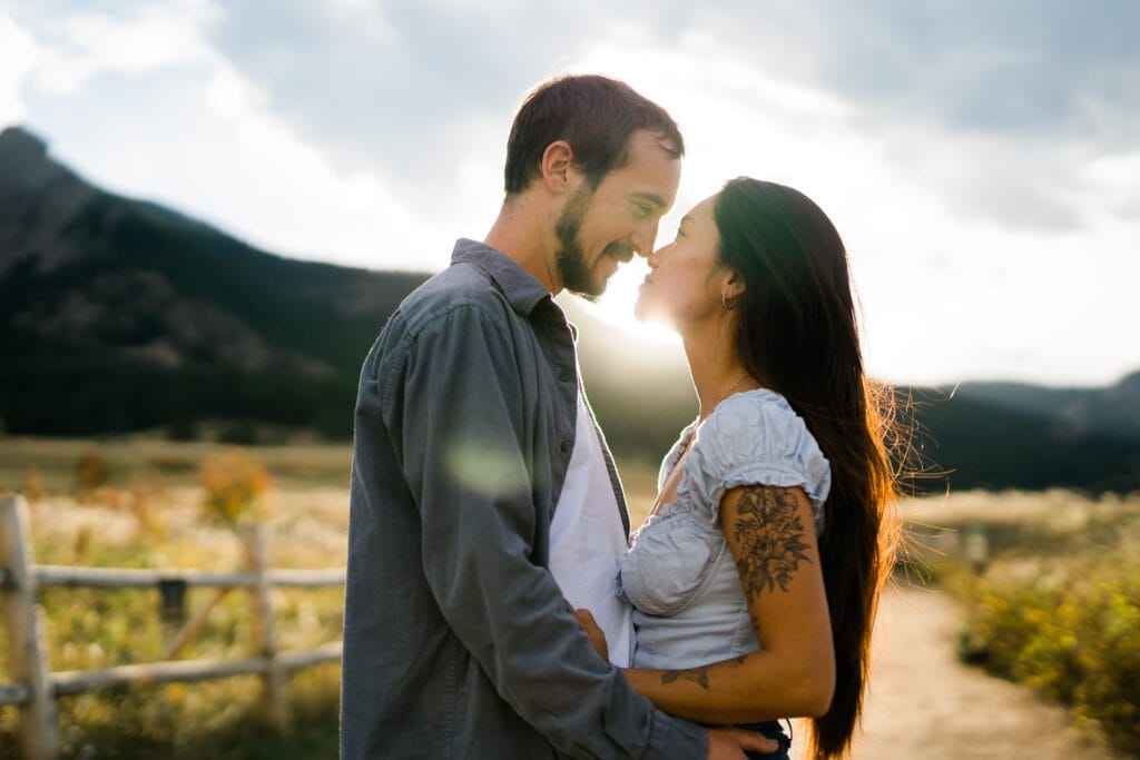 engaged couple looking at eachother and smiling at eachother during their Chautauqua park engagement photos