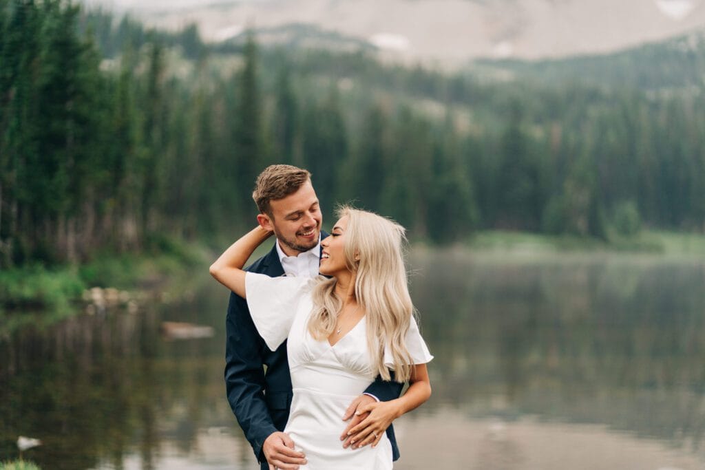 a couple laughing and smiling at the camera during their lake mitchell engagement photos