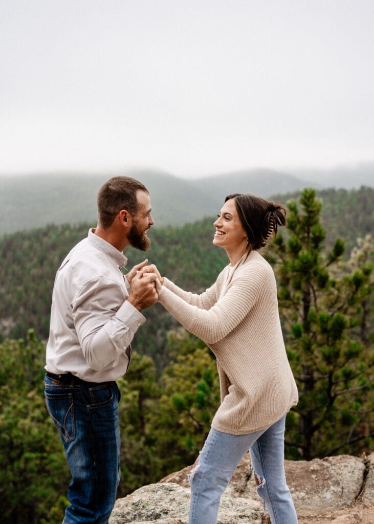 newly engaged couple playing around during their photoshoot during their proposal in colorado