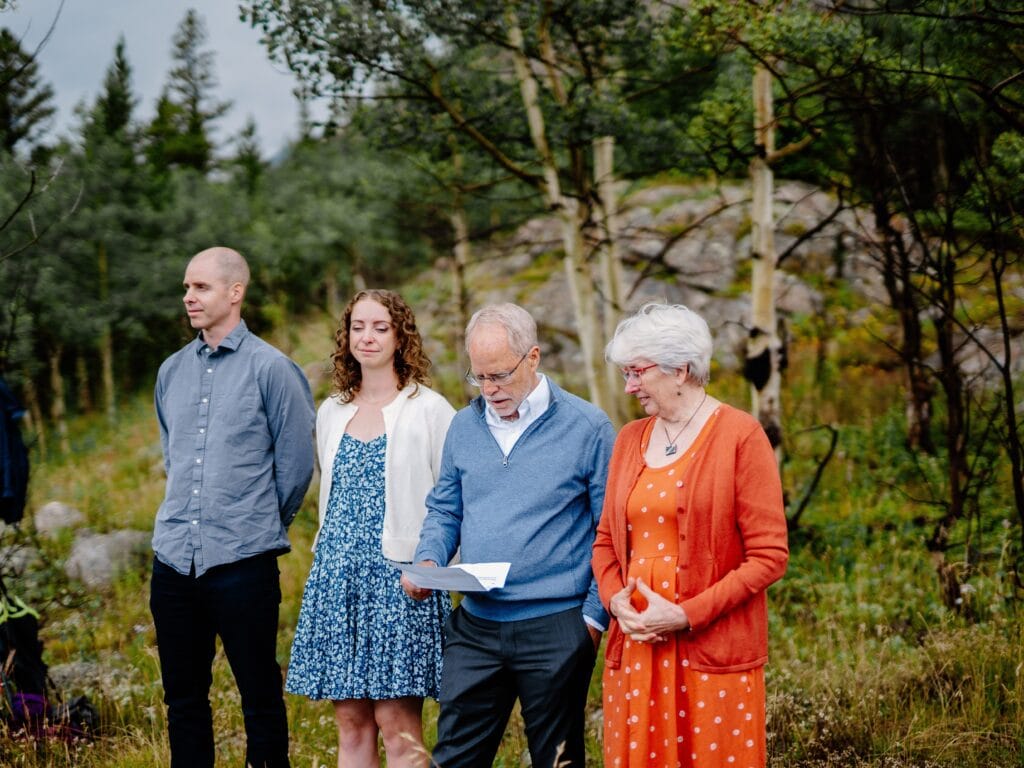 father of the groom reading ceremony script during couples eldora mountain colorado elopement at their family cabin