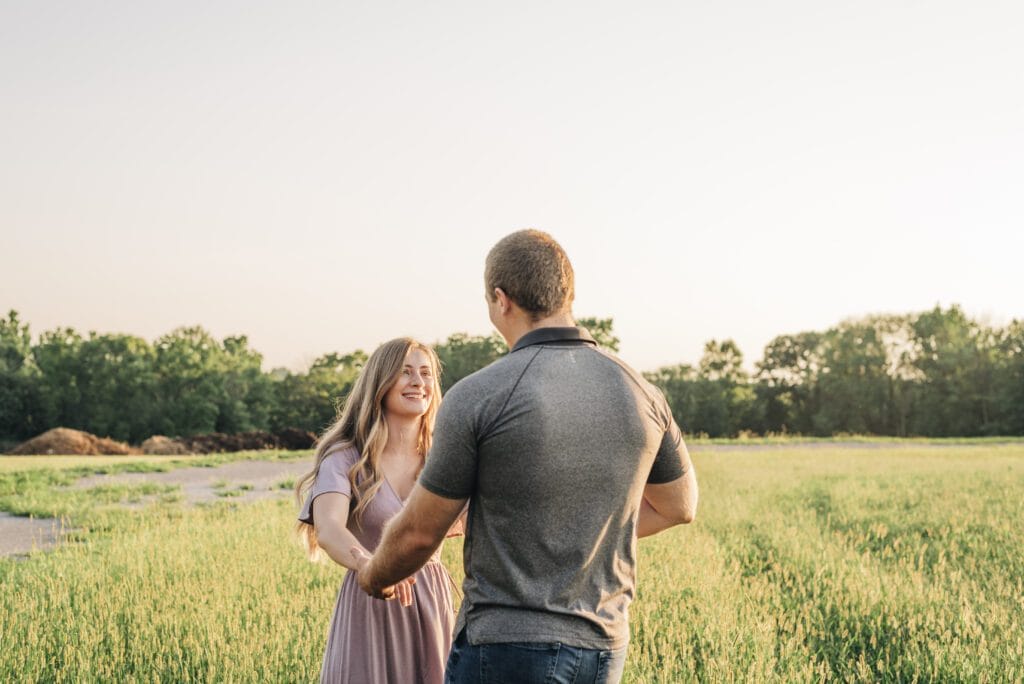 cute couple holding hands and swinging eachother around during their couples photoshoot