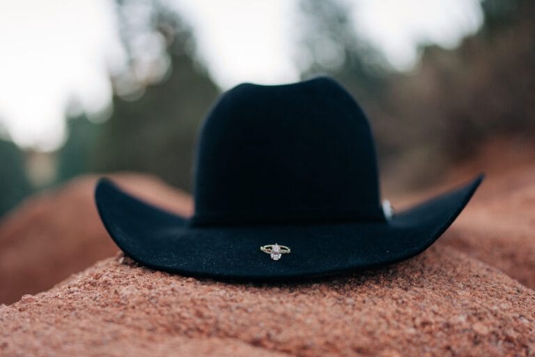 engagement ring sitting on top of cowboy hat during their garden of the gods photoshoot