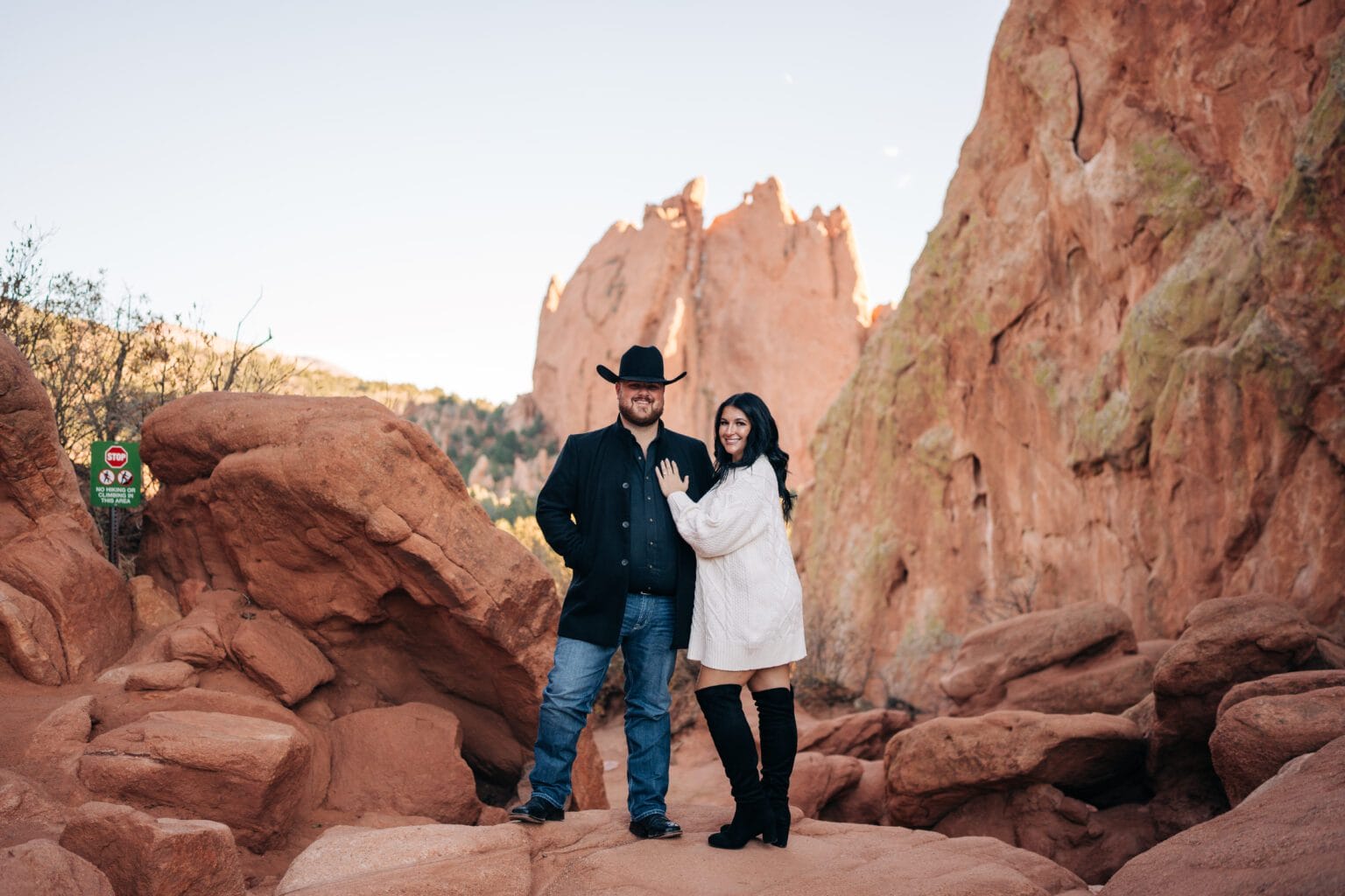girlfriend leaning on her boyfriend as they smile at the camera together during their garden of the gods photoshoot