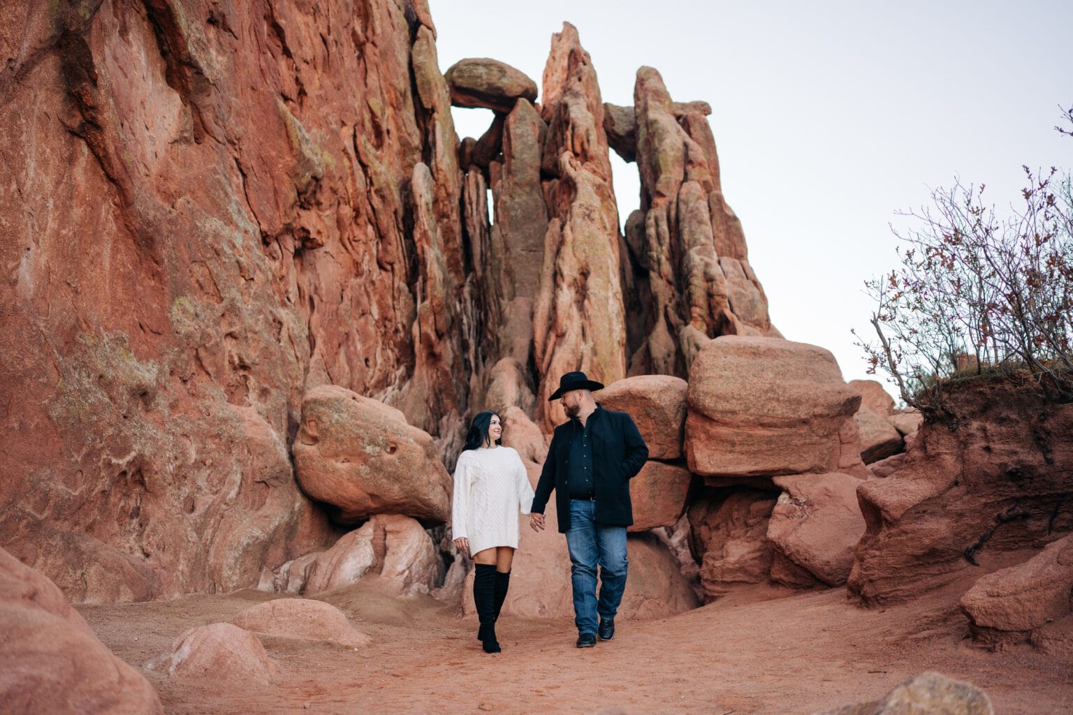 girlfriend and boyfriend holding hands and walking together during their garden of the gods photoshoot
