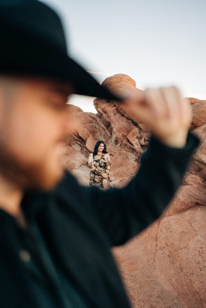 camera looking through boyfriends cowboy hat to see girlfriend at their Garden of the Gods proposal