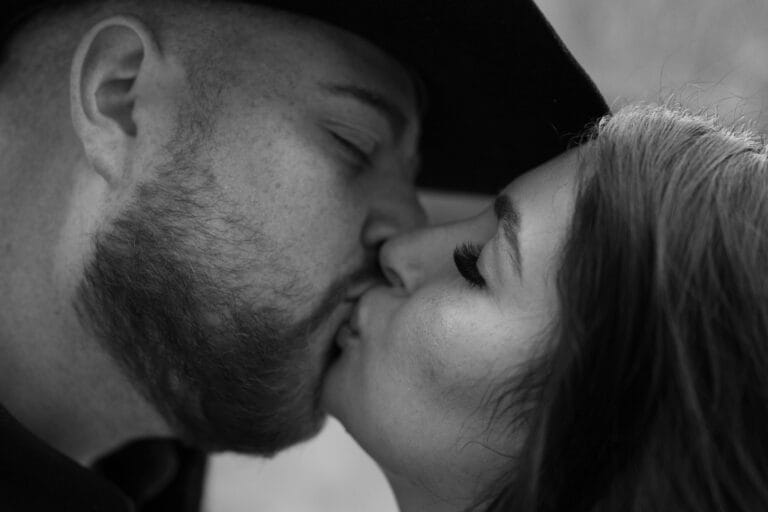 black and white photo of boyfriend and girlfriend kissing during their garden of the gods photoshoot