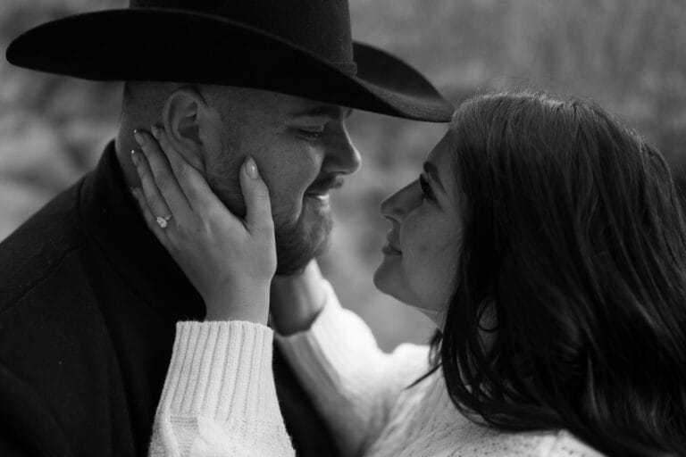 girlfriend holding her boyfriends face smiling at him closeup during their garden of the gods photoshoot
