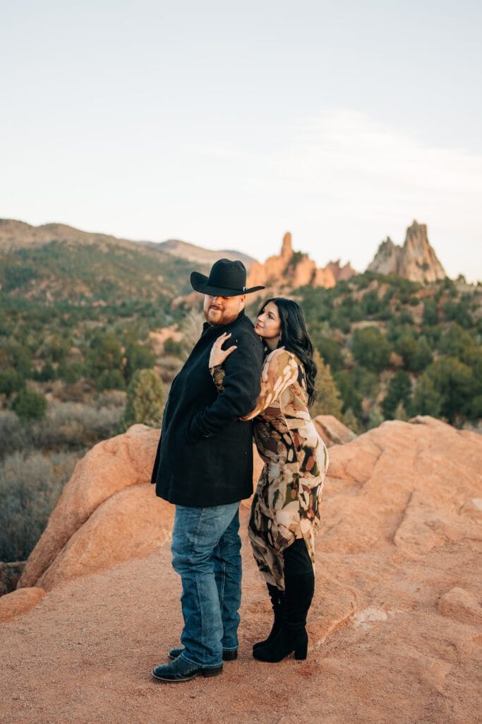 girlfriend hugging her boyfriend from behind and looking up at her boyfriend during their garden of the gods photoshoot