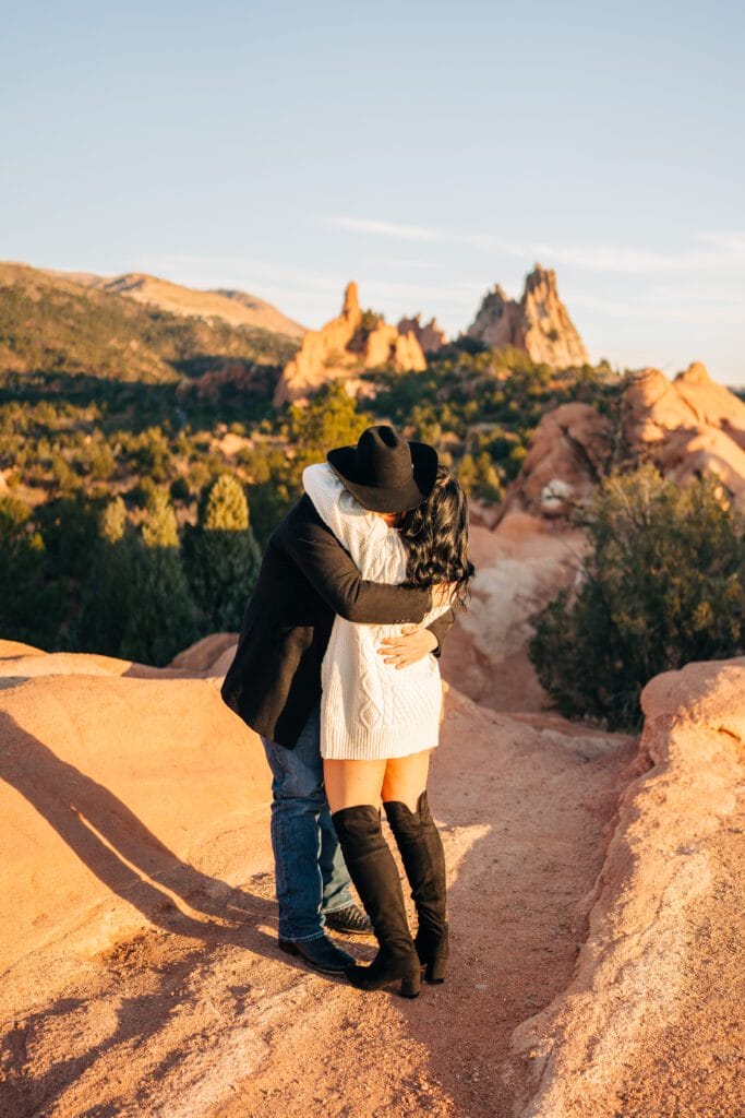 boyfriend and girlfriend hugging during their garden of the gods proposal photoshoot