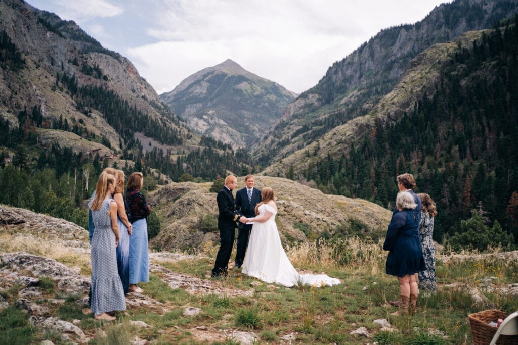 Bride and groom holding hands during their wedding ceremony during their Ouray Elopement