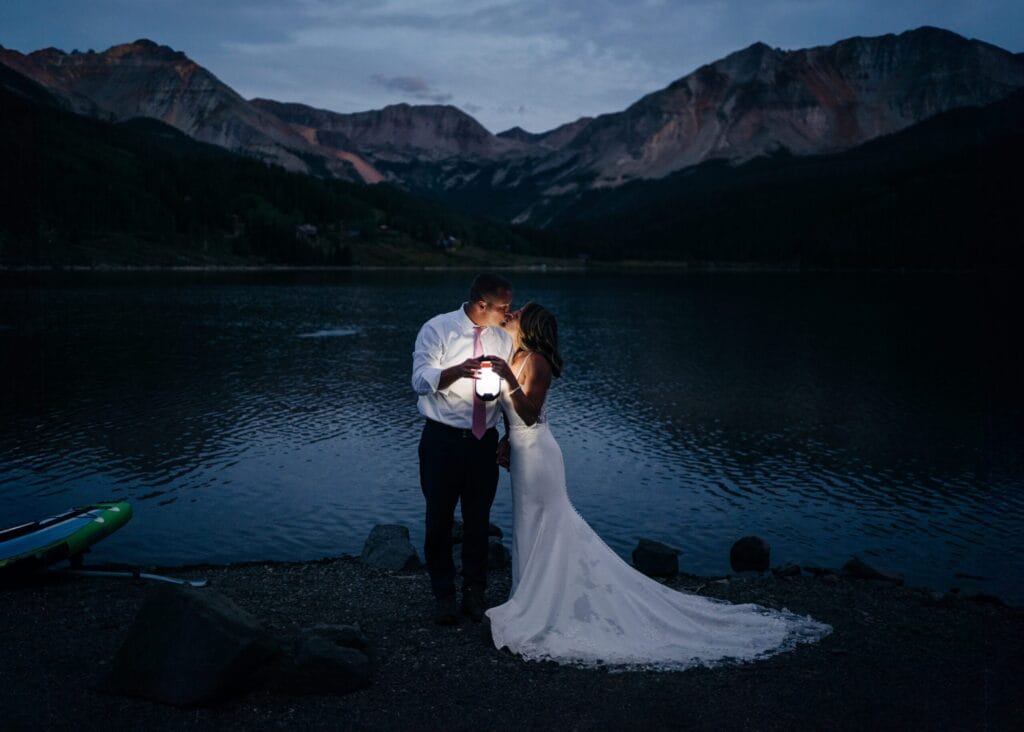 Bride and groom kissing and holding up a lantern during their Telluride elopement