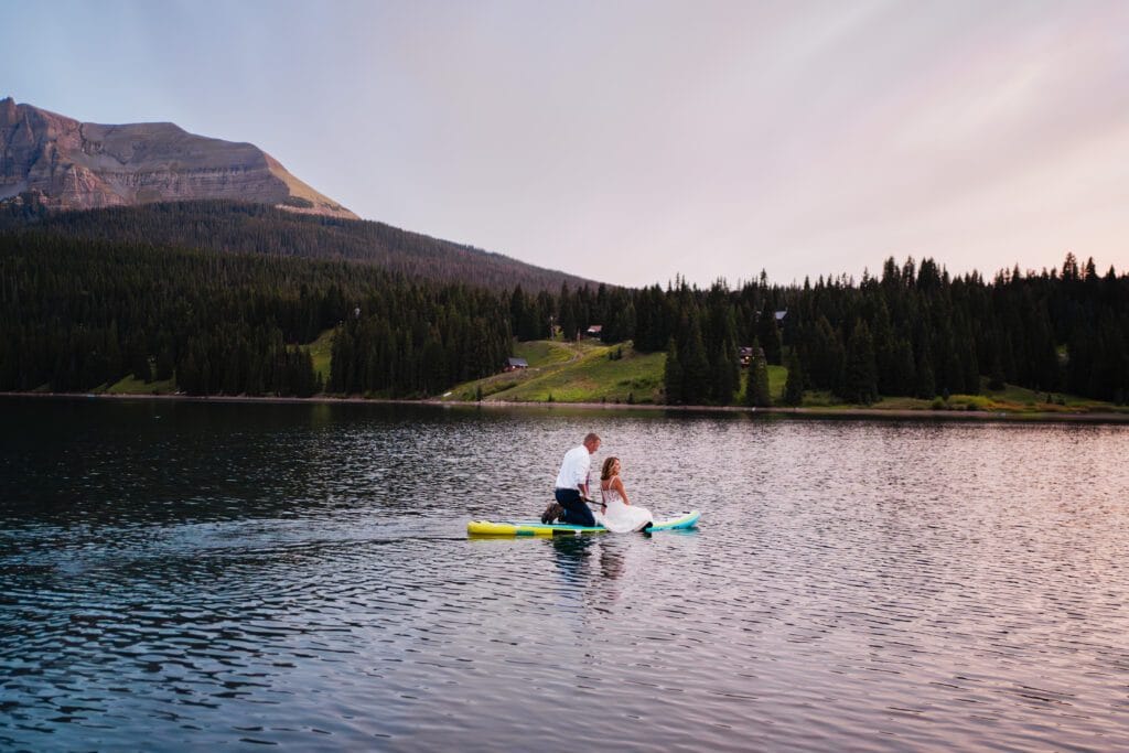 sunset photo of bride and groom paddleboarding during their Telluride elopement