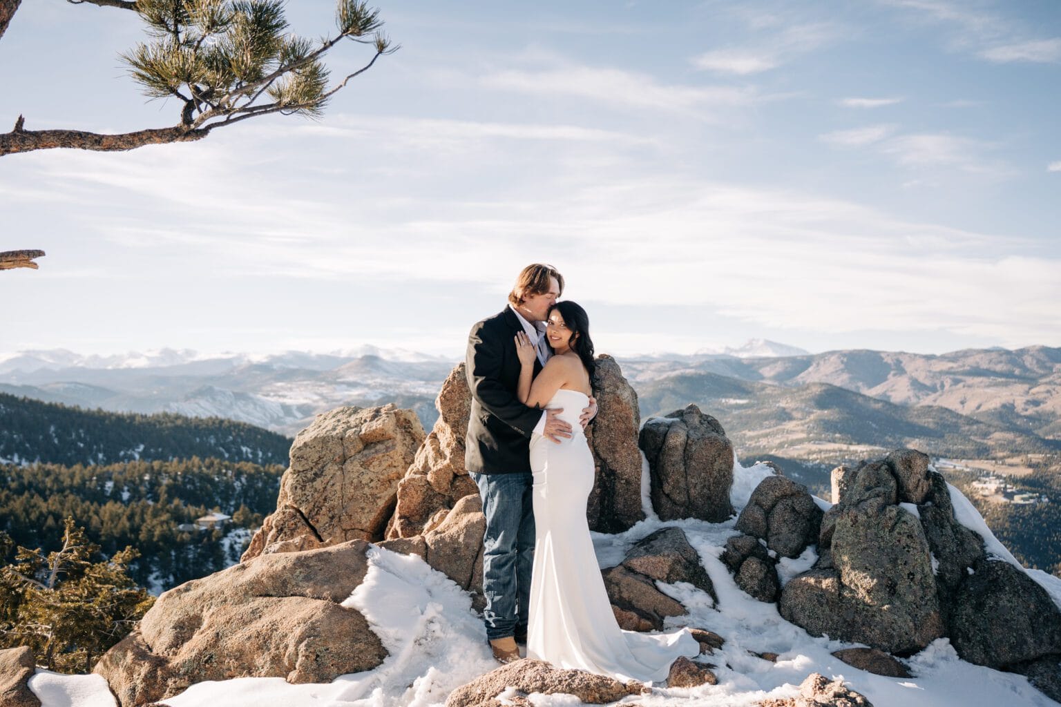 bride and groom snuggled up on top of a mountain during their boulder elopement in Colorado