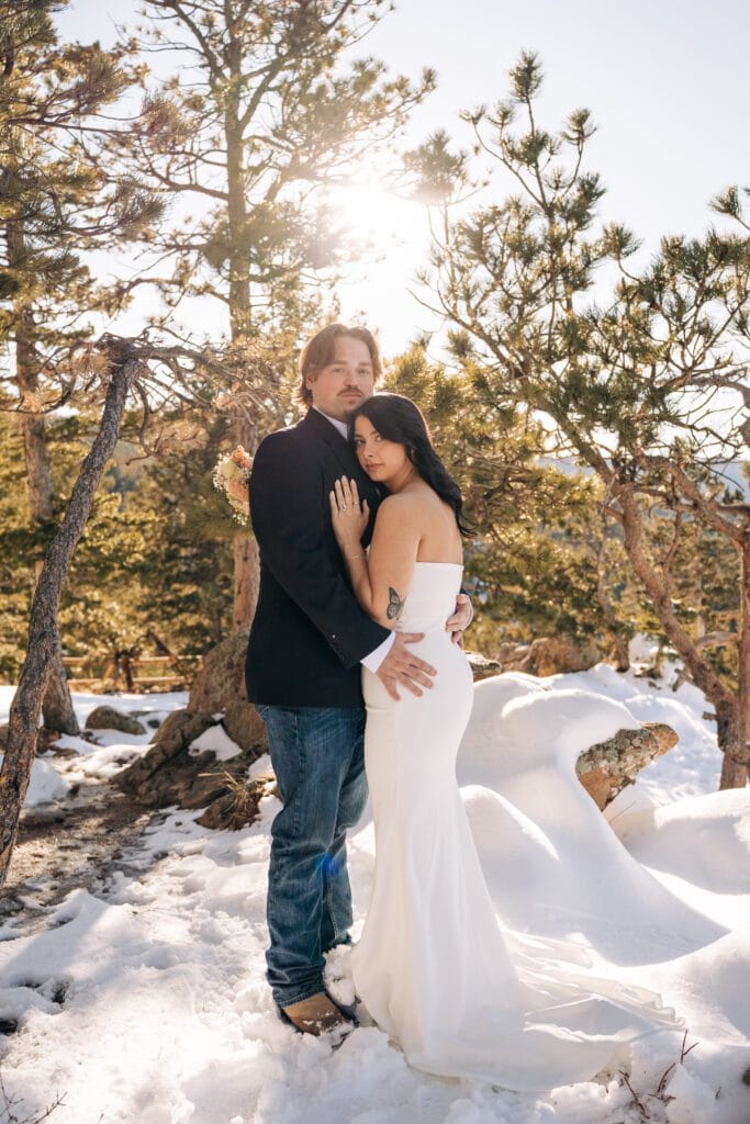 bride laying her head on grooms chest in a snowy forest at Lost Gulch Overlook during their Boulder elopement in Colorado