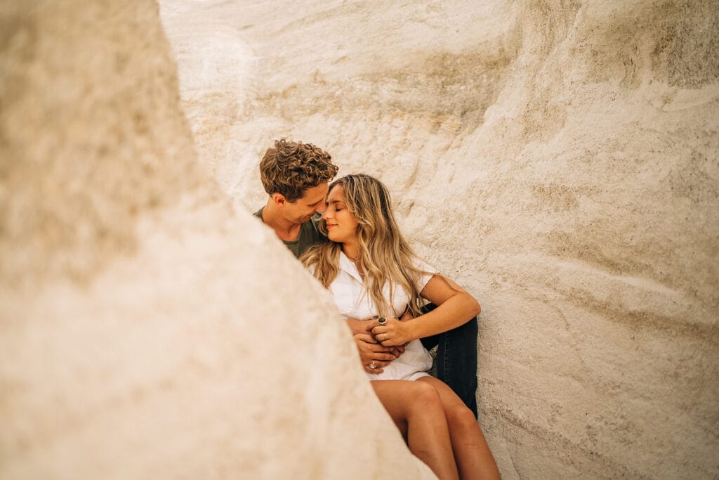 Couple sitting together with their noses touching during their photoshoot at the Colorado Paint Mines