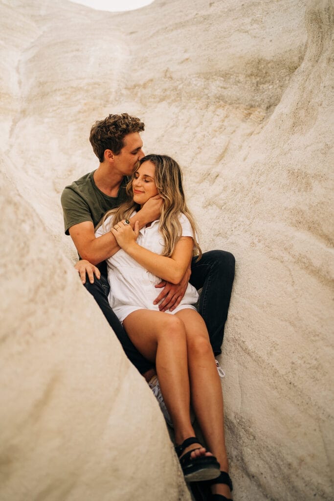 Couples sitting together in a slot canyon at the Colorado Paint Mines during their couples photoshoot