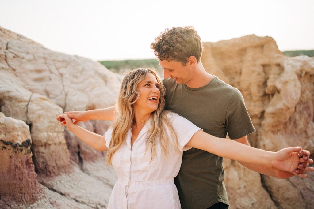 Couple holding hands and lifting their arms up in the air during their couples photoshoot at the Colorado Paint Mines