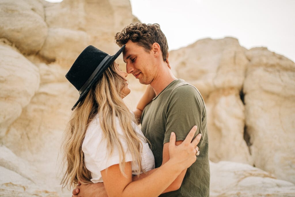 Couple smiling at each other and hugging at the Colorado Paint Mines during their couples photoshoot
