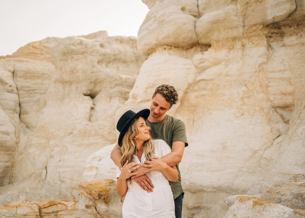 Close up of boyfriend hugging girlfriend from behind during their couples photoshoot at the Colorado Paint Mines