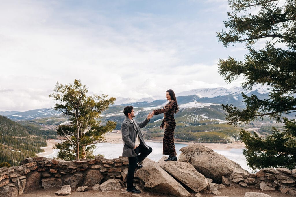Eric helping Chelsea down off the rocky outcropping at Sapphire Point Overlook in Breckenridge, CO