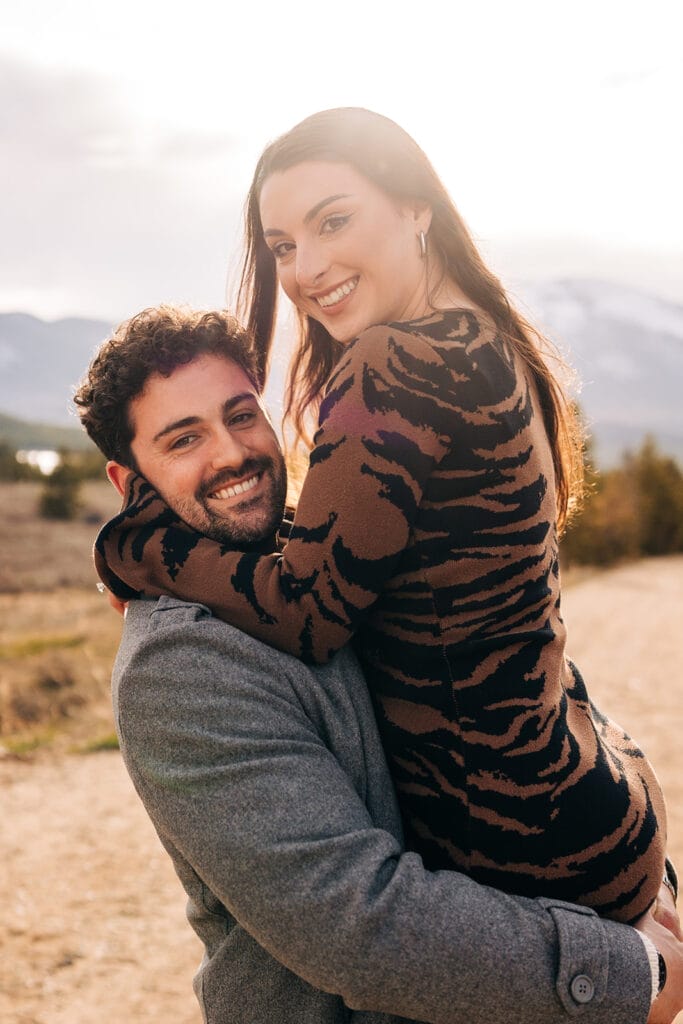 Chelsea and Eric smiling at camera during their engagement photos at Sapphire Point Overlook.