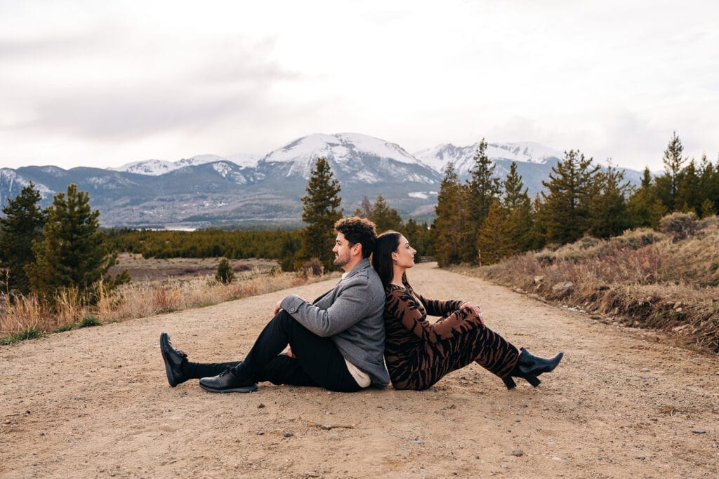 Couple sitting back-to-back on a road near Sapphire Point Overlook in Breckenridge, Colorado