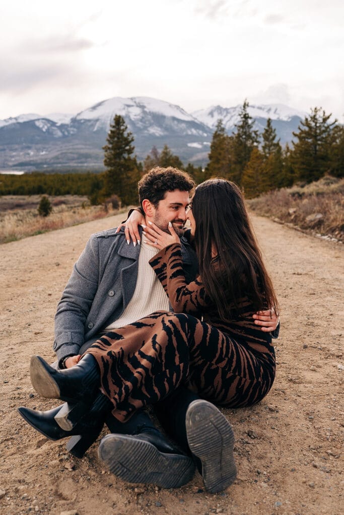 Chelsea and Eric sitting and smiling at eachother during their engagement photos at Sapphire Point