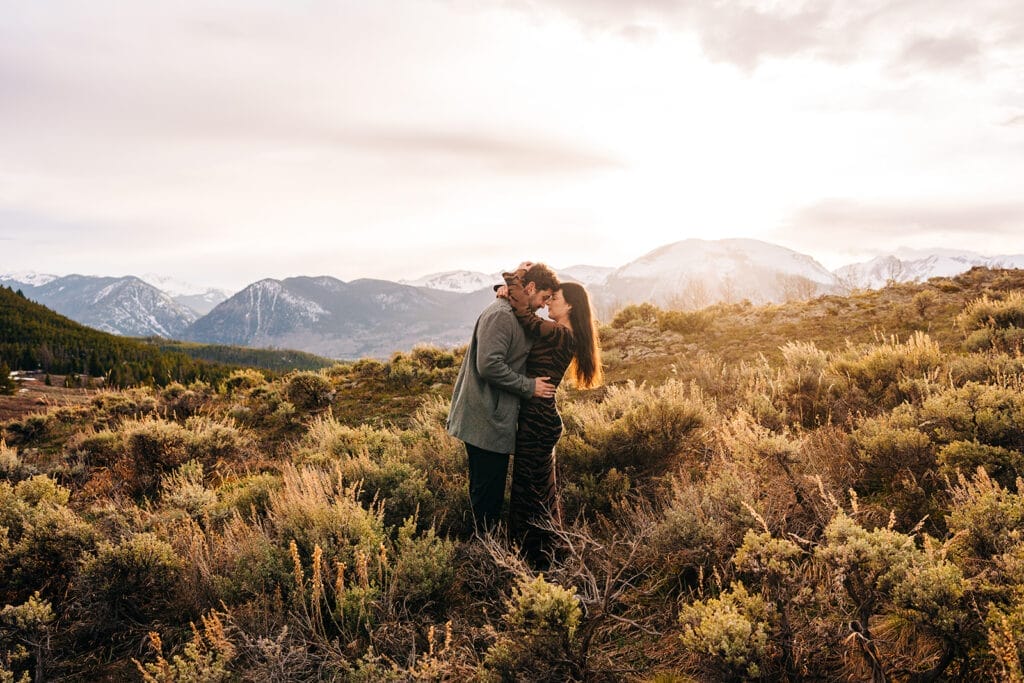 Couple embracing at Sapphire Point Overlook in a meadow at sunset