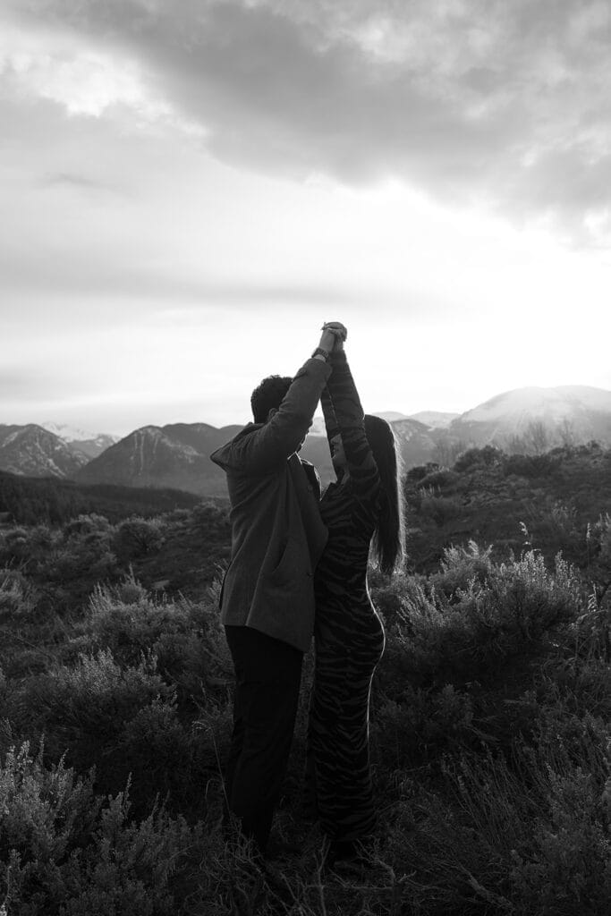 Couple dancing in mountain landscape at sunset