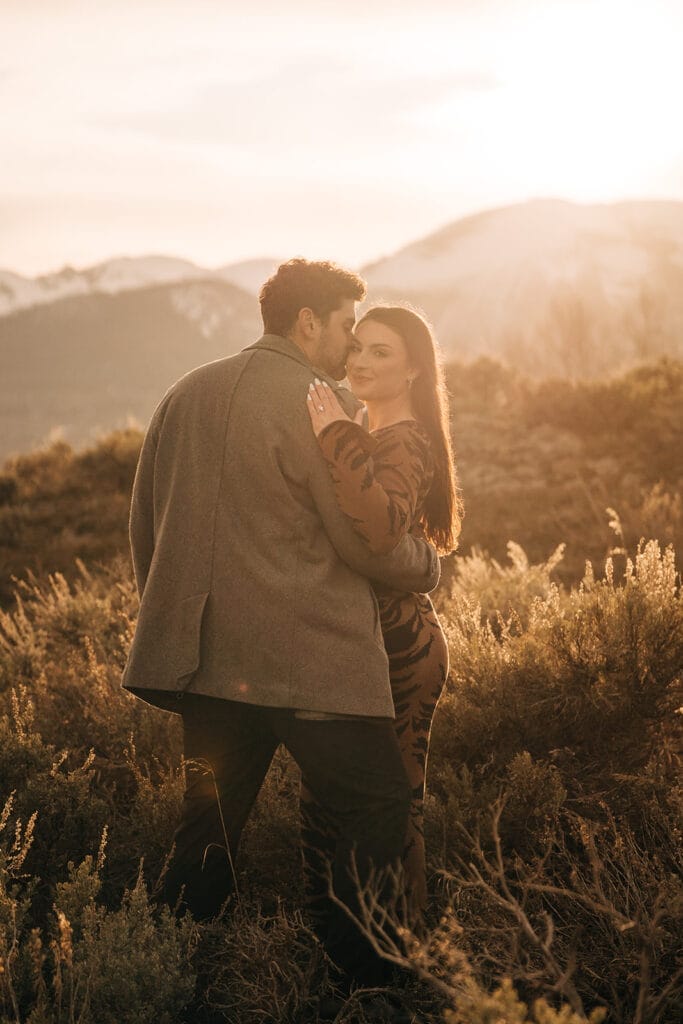 Chelsea side hugging eric and smiling at the camera during peak sunset at Sapphire Point Overlook