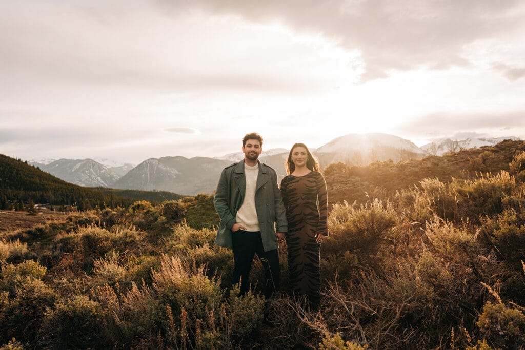 Eric and Chelsea holding hands in a meadow at Sapphire Point Overlook during sunset