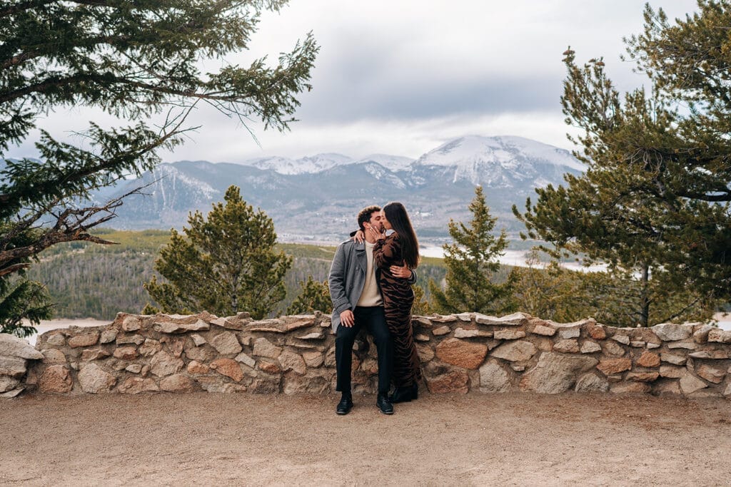 Engaged couple Eric + Chelsea kissing at Sapphire Point Overlook after their proposal