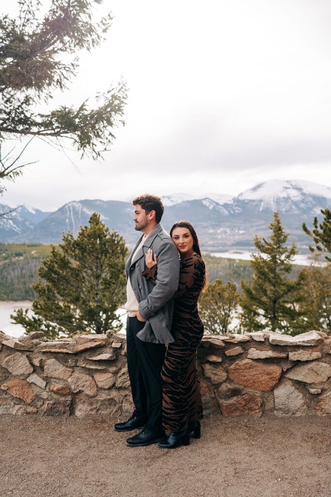 Chelsea hugging Eric from behind as she looks at the camera at Sapphire Point Overlook during their engagement photos