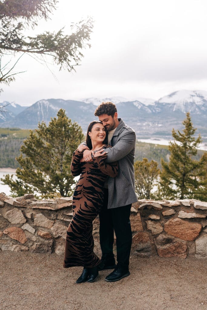 Eric hugging Chelsea from behind after he proposed to her at Sapphire Point Overlook in Breckenridge, CO